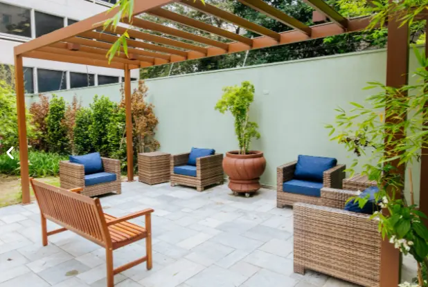 Jardim com pergolado e área de convivência